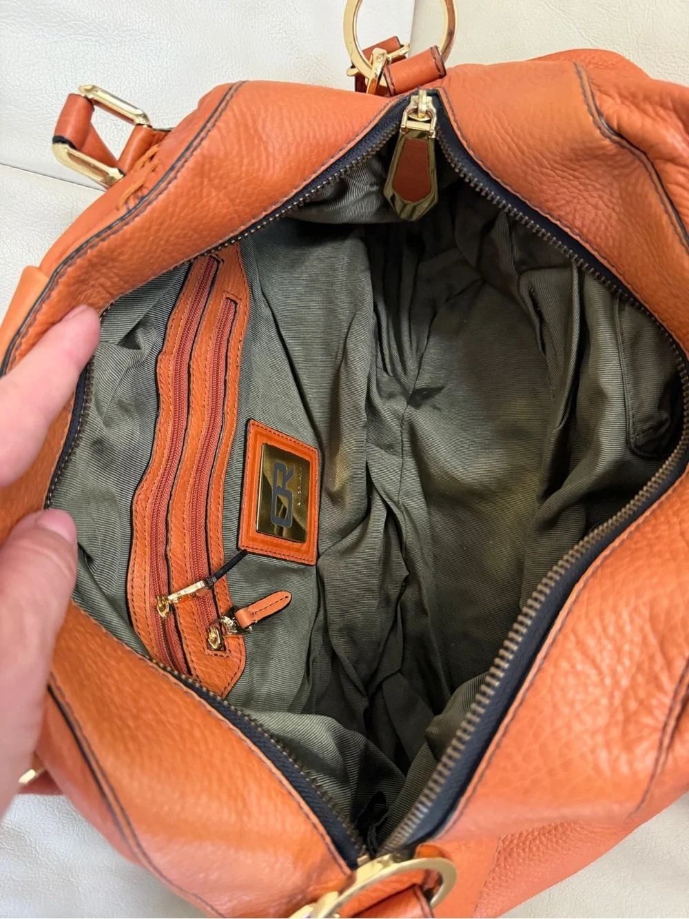Orange leather handbag appears to be a slouchy style by orYany